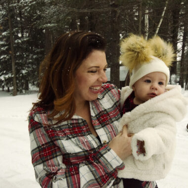 Woman holding baby in the snow