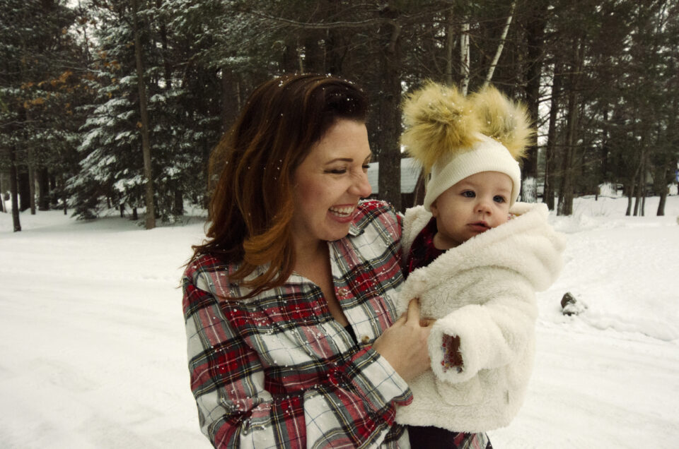 Woman holding baby in the snow