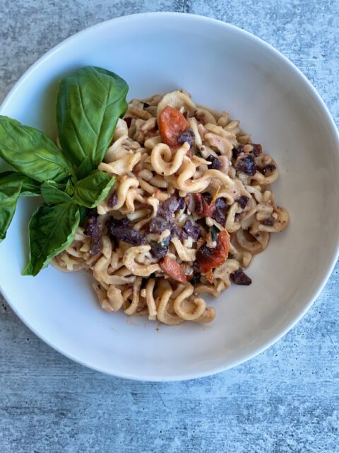 Image of pasta in a bowl with a basil garnish