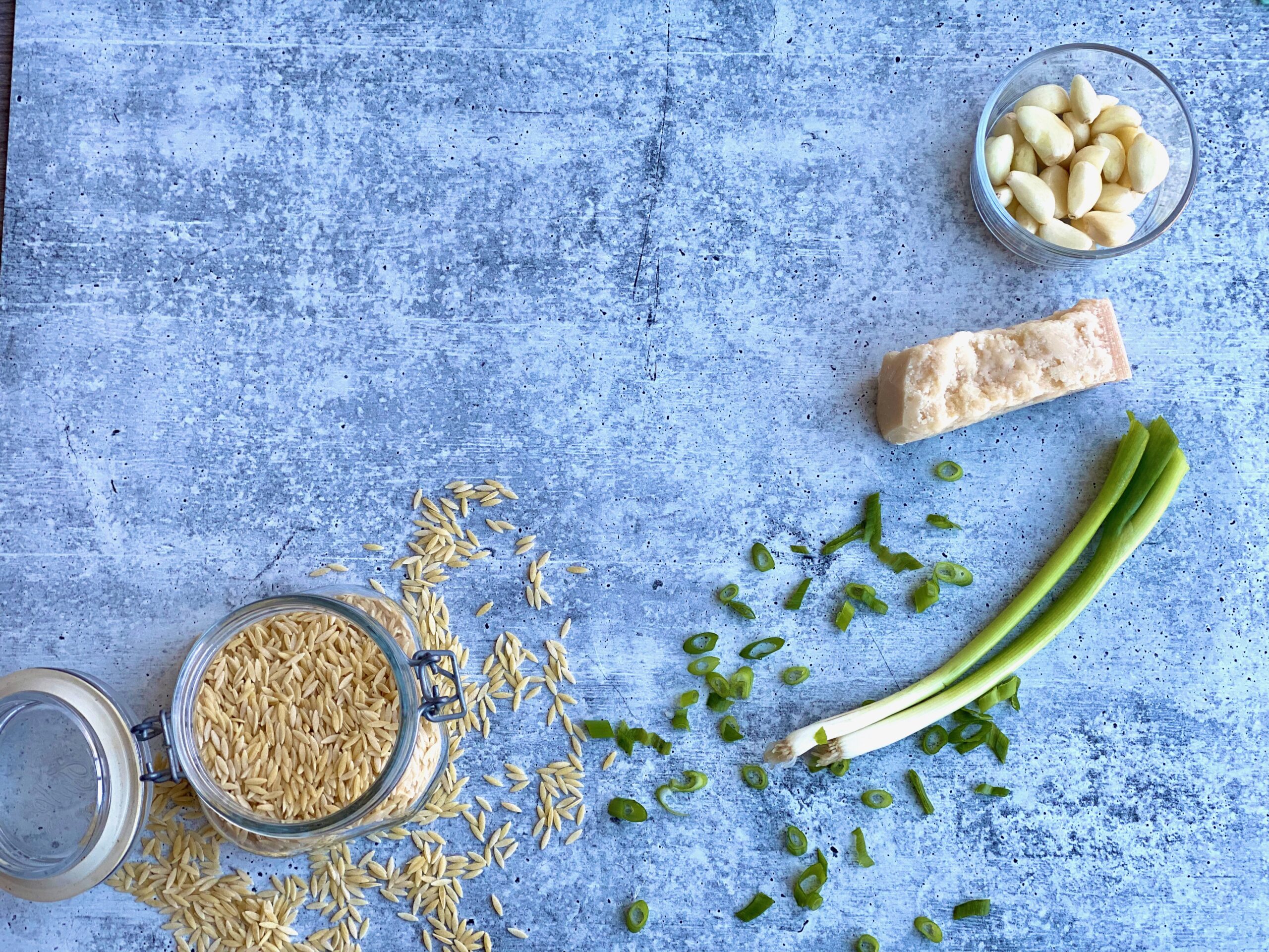 An image of noodles, scallions,parmesan cheese and garlic 