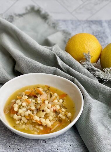 Picture of a bowl of soup with lemons in the background