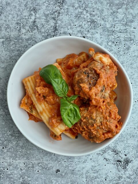 A bowl with pasta and meatballs