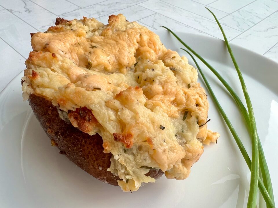 Picture of a chive twice baked potatoes with chives in the background